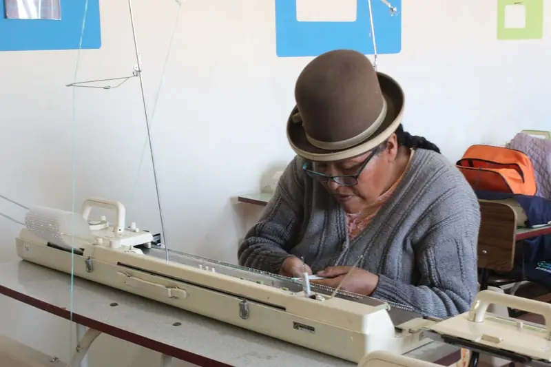 Mujer tejiendo en una máquina de tejer